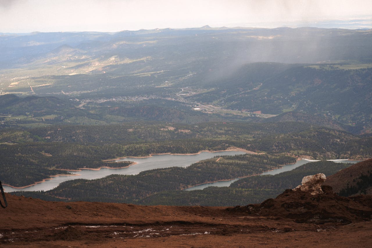 Scenic view from Pikes Peak summit showcasing expansive forested valley and reservoir.
